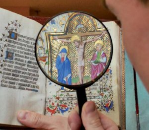 Un bibliofilo studia una miniatura da
un “libro delle ore” del Cinquecento. - Archivio BPP