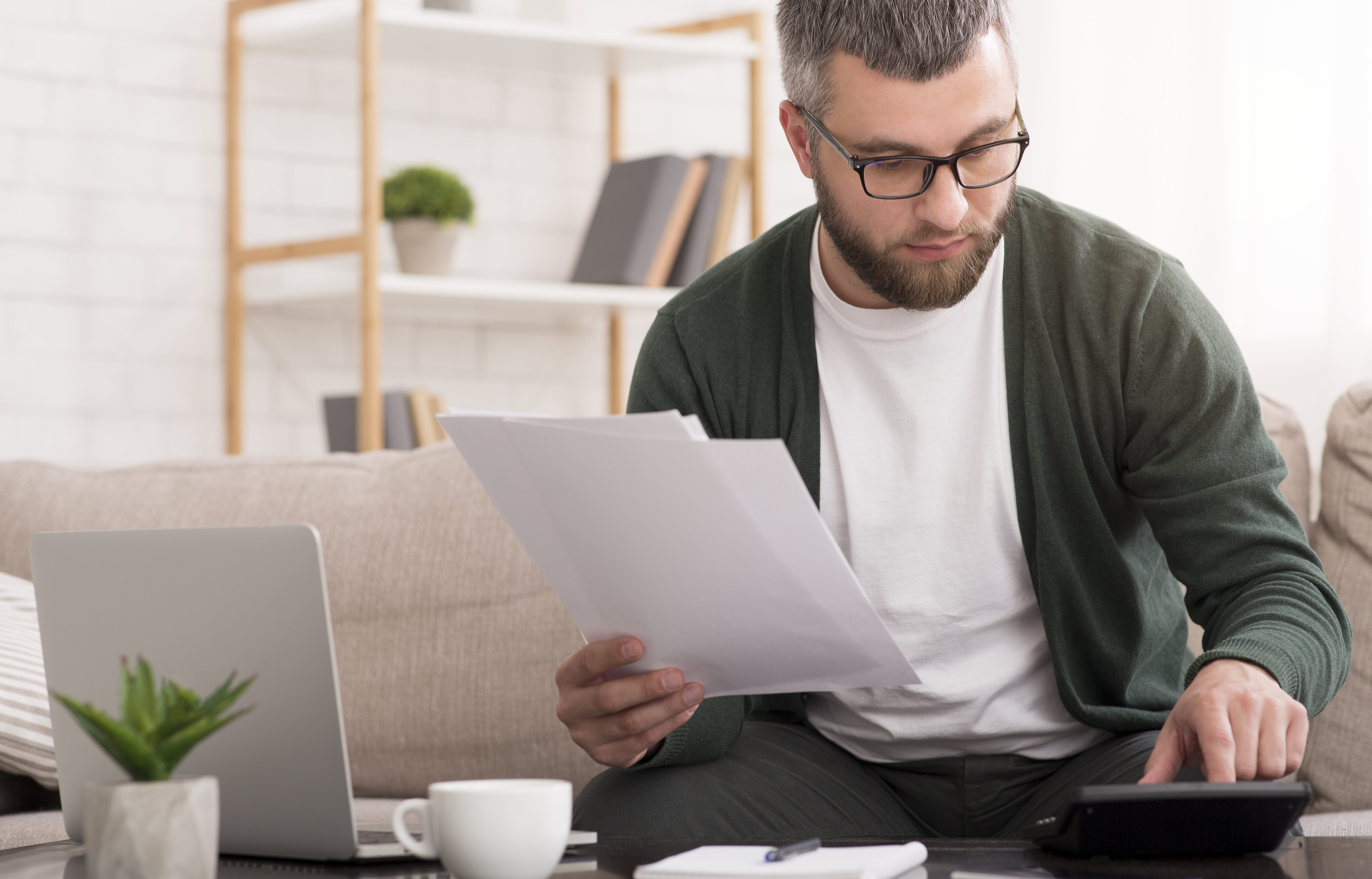 man-with-calculator-counting-money-and-checking-bi-QBA8KYC man-with-calculator-counting-money-and-checking-bi-QBA8KYC